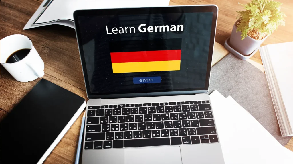 Almanca özel ders için Learn German ekranı ve Almanya bayrağı gösteren dizüstü bilgisayar